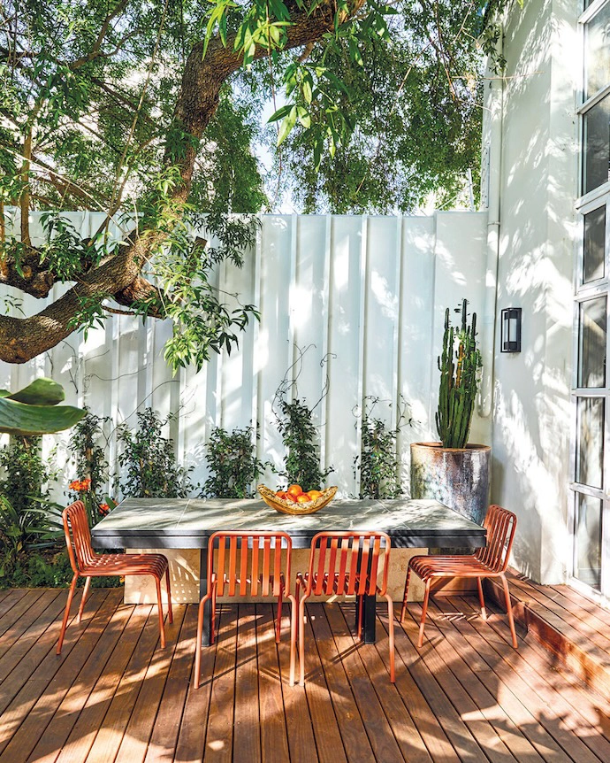 The white wall in the courtyard carries the same timber batten spacing as the mirror wall inside.