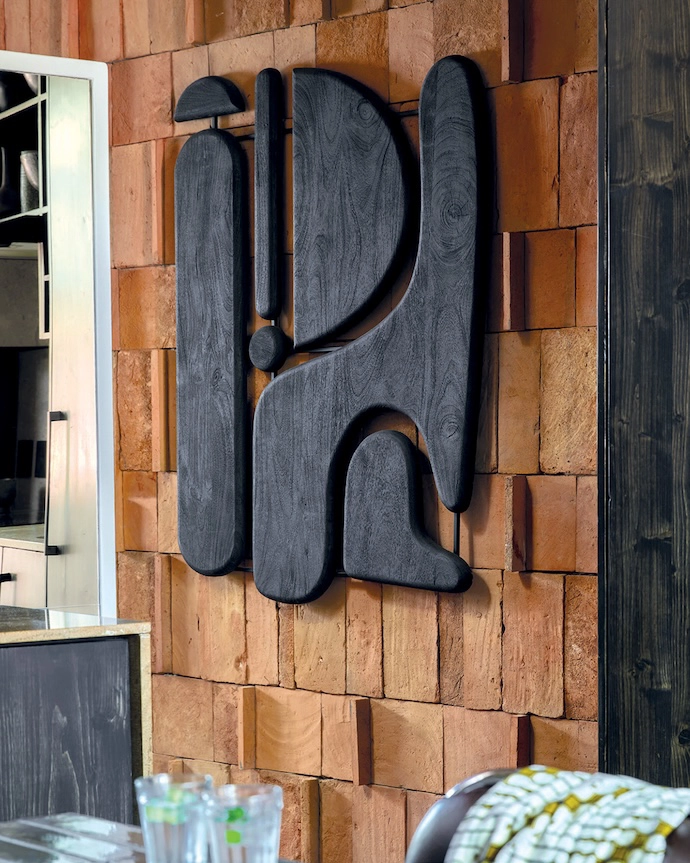 The solid grain of the wooden artwork stands out against the tiles.