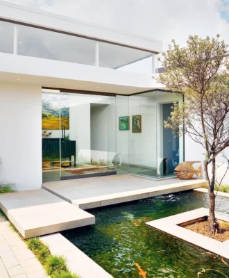 Two slabs suspended over a koi pond lead visitors to the front door.