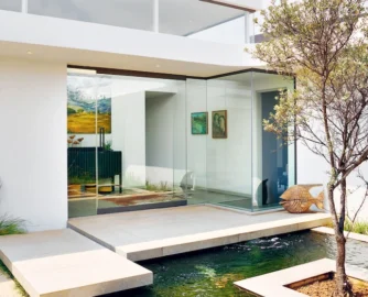 Two slabs suspended over a koi pond lead visitors to the front door.
