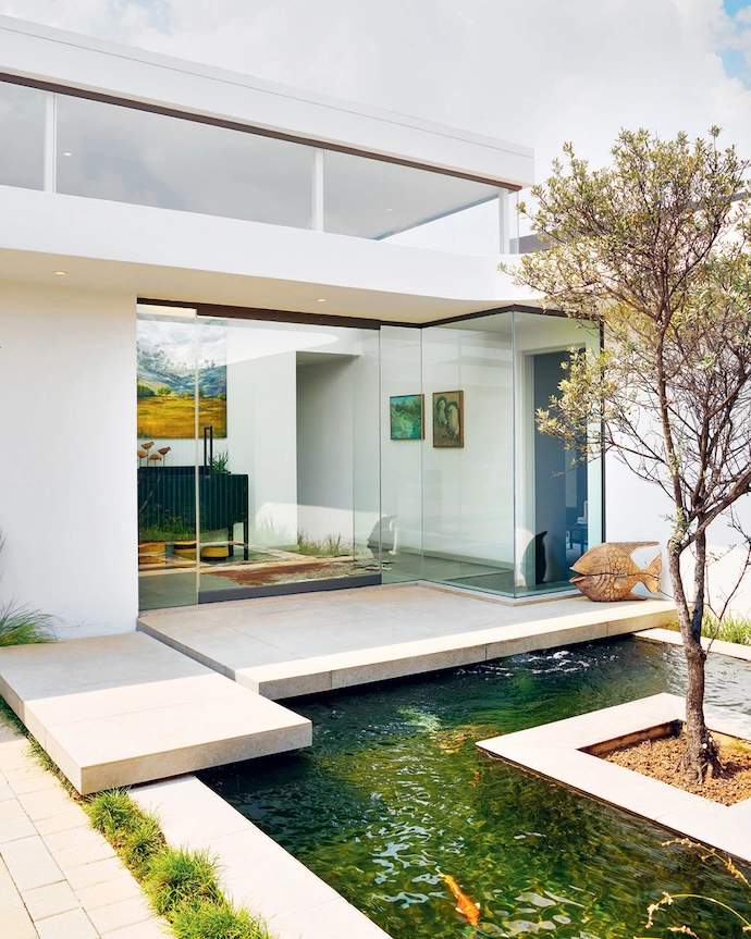 Two slabs suspended over a koi pond lead visitors to the front door.