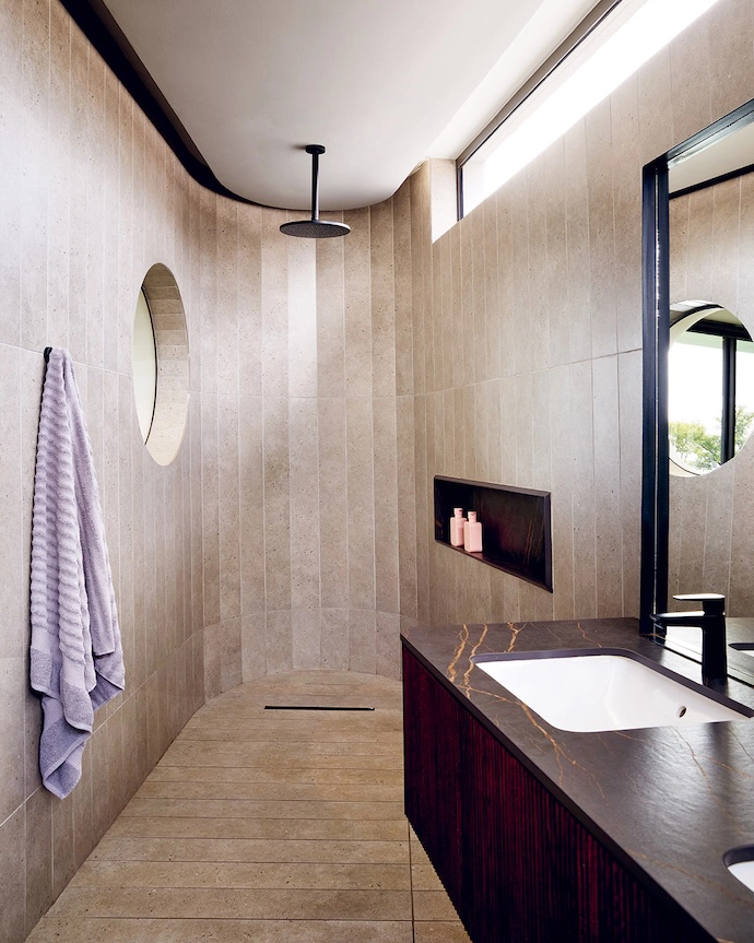 Another porthole provides a framed view of the garden and golf course from the main en suite shower.