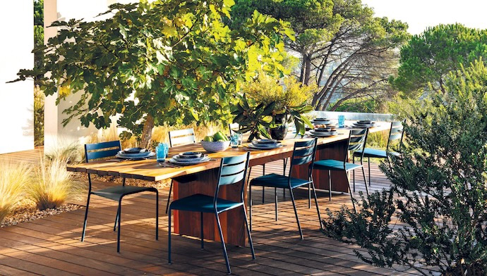 Outdoor dining is a family affair at the walnut table from the Muda collection by Christophe, with Facto chairs by Patrick Jouin for Fermob.