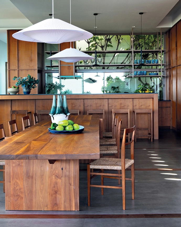 Designed by Christophe primarily in ultra-chic walnut, the kitchen also features Cadeira Superligeira chairs by Daciano da Costa, and Alto barstools by Porventura. The Margres stoneware flooring is punctuated by Ipé wood slats.