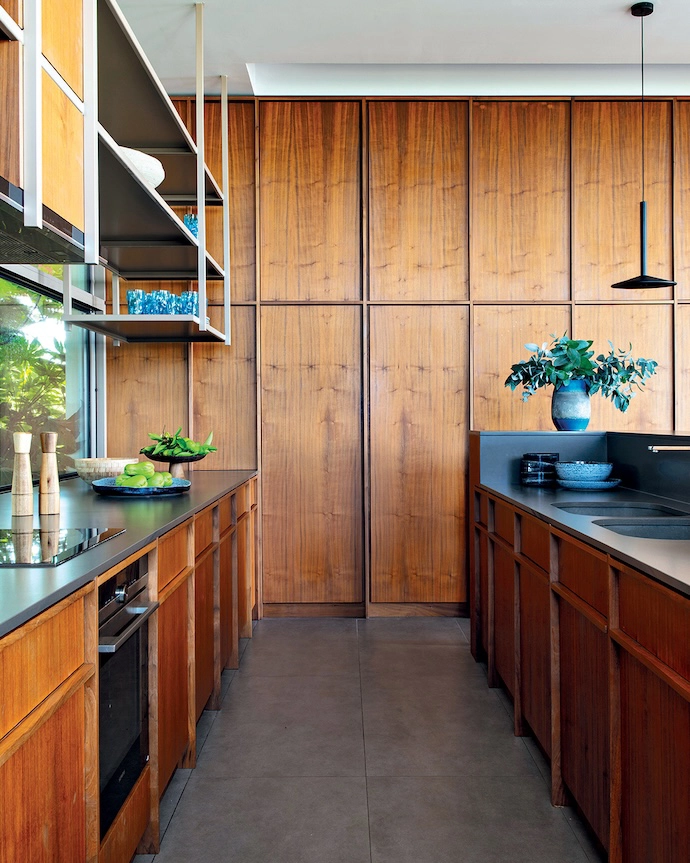 Designed by Christophe primarily in ultra-chic walnut, the kitchen also features Cadeira Superligeira chairs by Daciano da Costa, and Alto barstools by Porventura. The Margres stoneware flooring is punctuated by Ipé wood slats.