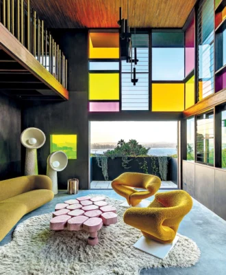 “The stained glass windows are such a bold move, especially in a house with incredible views – most homeowners wouldn’t want to obstruct them,” says interior designer Jase Sullivan. The colour palette is reinforced by the inclusion of two 1960s Pierre Paulin Ribbon chairs and a pink DenHolm coﬀee table.