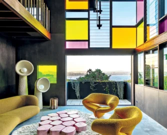 “The stained glass windows are such a bold move, especially in a house with incredible views – most homeowners wouldn’t want to obstruct them,” says interior designer Jase Sullivan. The colour palette is reinforced by the inclusion of two 1960s Pierre Paulin Ribbon chairs and a pink DenHolm coﬀee table.