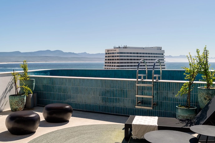 A rooftop plunge pool overlooks Beacon Island Hotel and the ocean and coastline beyond.