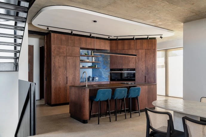 Another (matching) kitchen features a similar blue stone wall by Infinity Surfaces, inspired by the colours of the ocean, adding a layer of natural material to the palette of concrete, steel and glass.