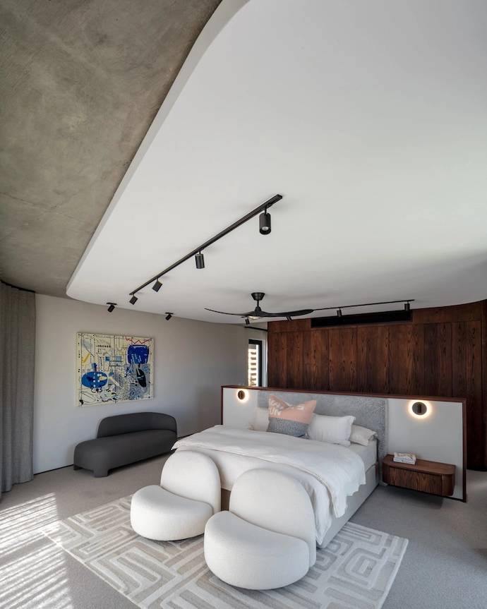 The home’s polished concrete floors are layered with rugs by The Ninevites. The Mama’s Gun cushion that celebrates Black literature (another reference to the owner’s love of art and literature) is also by The Ninevites. The chairs, part of the Élysée collection by Pierre Paulin, are from Ligne Roset, as is the Taru settee. The artwork is by Maja Maljević.